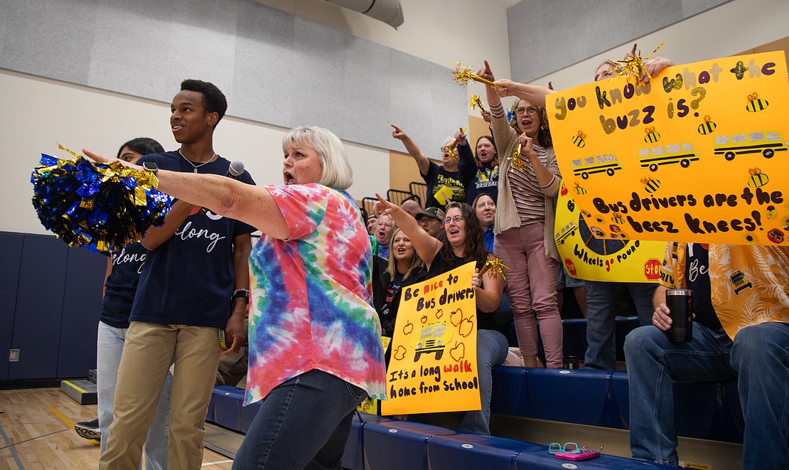 Ferndale Student School Board member Kwabena Ledbetter holds the microphone for bus driver Carla DeSoto as she cheers at the Ferndale School District staff rally at the high school on Tuesday, Aug. 29.