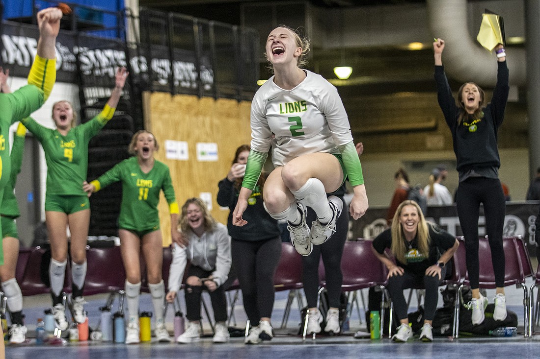 Lynden's Mya VanderYacht (2) leaps into the air in celebration Nov. 19, 2022, after the Lions scored the match point against Washington (Tacoma) in the 2A state tournament fifth/sixth-place game.