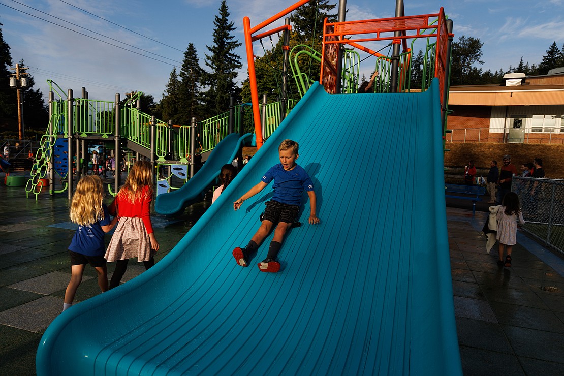 After the bell rings for classes to begin, Espen Turner gets in one more ride down the new slide on the first day of school. Students were exploring the new inclusive playground.