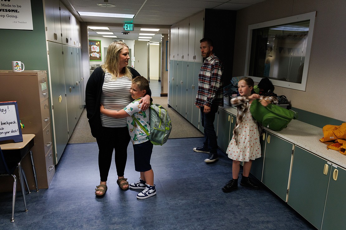 Roman Larsen gives mom Taffy a hug as husband Jacob and daughter Sierra head to another classroom on the first day of school.