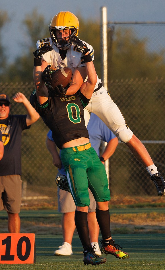 Ferndale's Conner Walcker leaps for the ball as Lynden’s Cooper Moore (0) breaks up the pass.