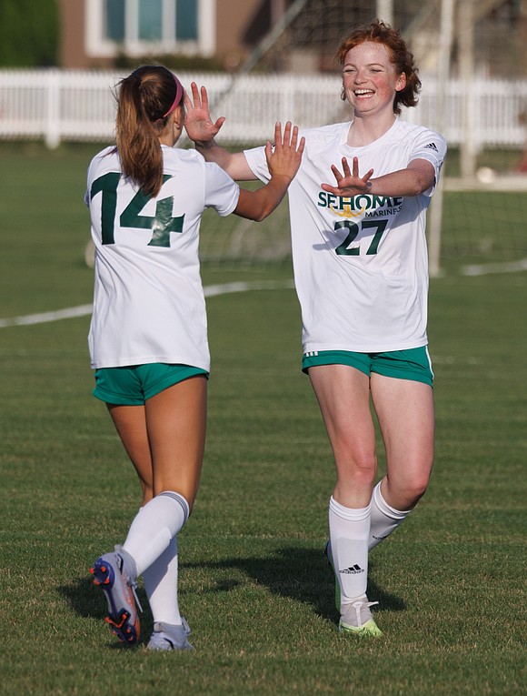 Sehome’s Ella Perry, left, high-fives Sehome’s Alena Navaiux who scored the final goal for Sehome.