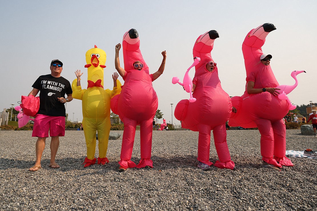 Dressed in inflatable flamingo suits, racers on team YMCA Department of Fun cheer on a teammate in the paddling leg of the Bellingham Traverse on Aug. 19 at Waypoint Park.