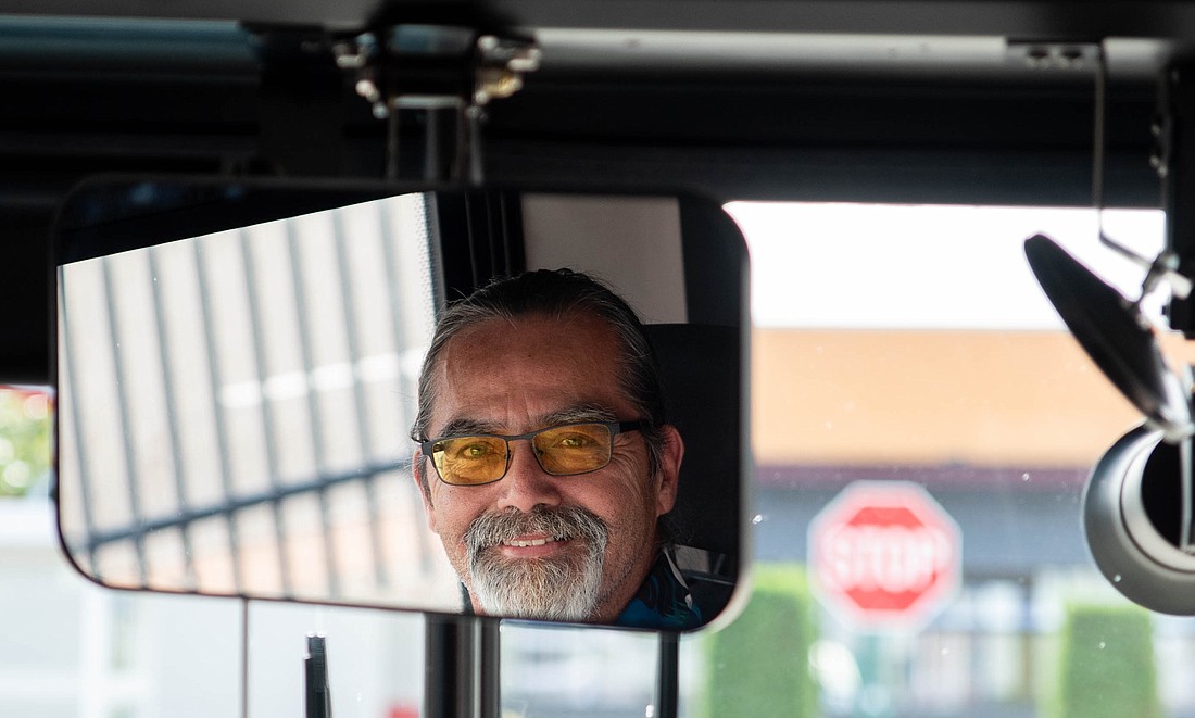 Whatcom Transportation Authority bus driver Jeff James smiles in the reflection of the bus' rearview mirror. James has been driving for WTA for 33 years and said he appreciates all the people he's had the chance to meet and help in his role.