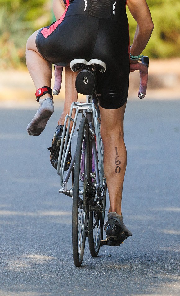 Tarae Griffin tries to get her foot into her shoes, pre-attached to the pedals, while taking off on the bike leg of the Lake Whatcom Triathlon July 8.