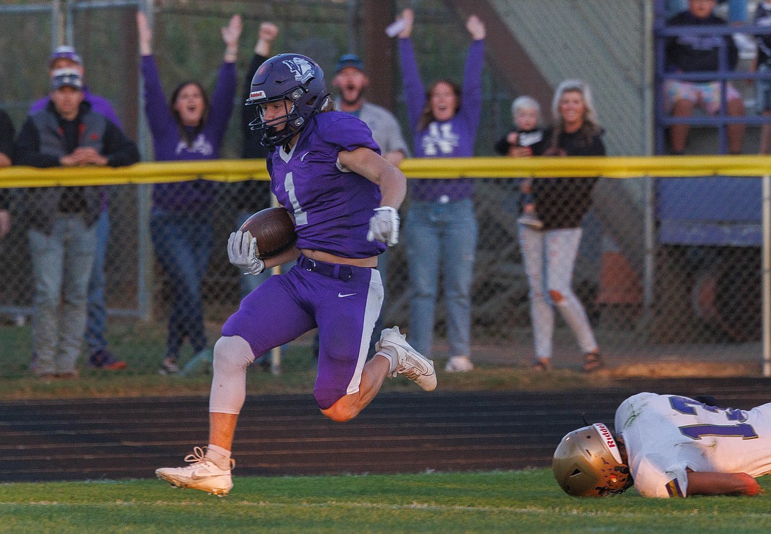 As fans celebrate behind him, Nooksack Valley’s Jackson Bennett scores on a 63-yard touchdown reception Friday, Sept. 8, in the Pioneers’ 63-14 win over Connell at Civic Stadium.