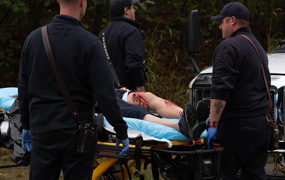 A volunteer "victim" with fake leg wounds is wheeled away by first responders during an airport emergency exercise in 2023.