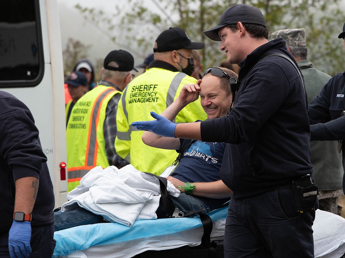 A volunteer victim laughs with a first responder while being moved on gurney away from the scene. The airport emergency exercise was conducted on Friday, Sept, 8, 2023.