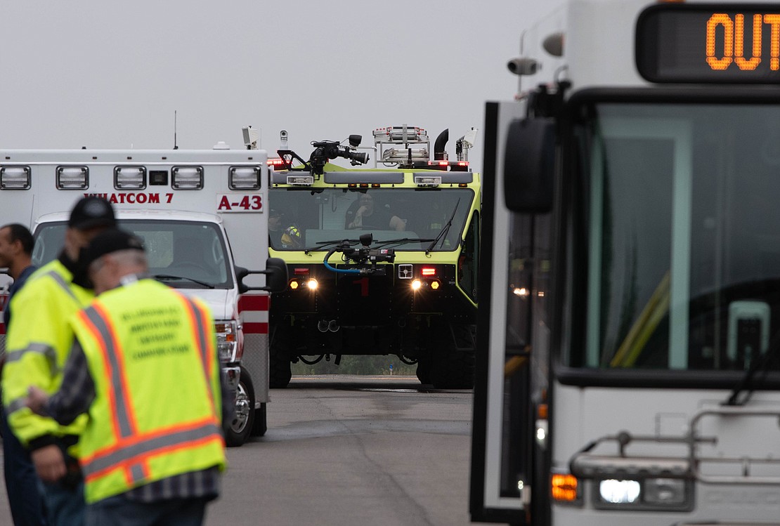 The airport's Aircraft Rescue and Firefighting truck waits behind an ambulance and WTA bus.