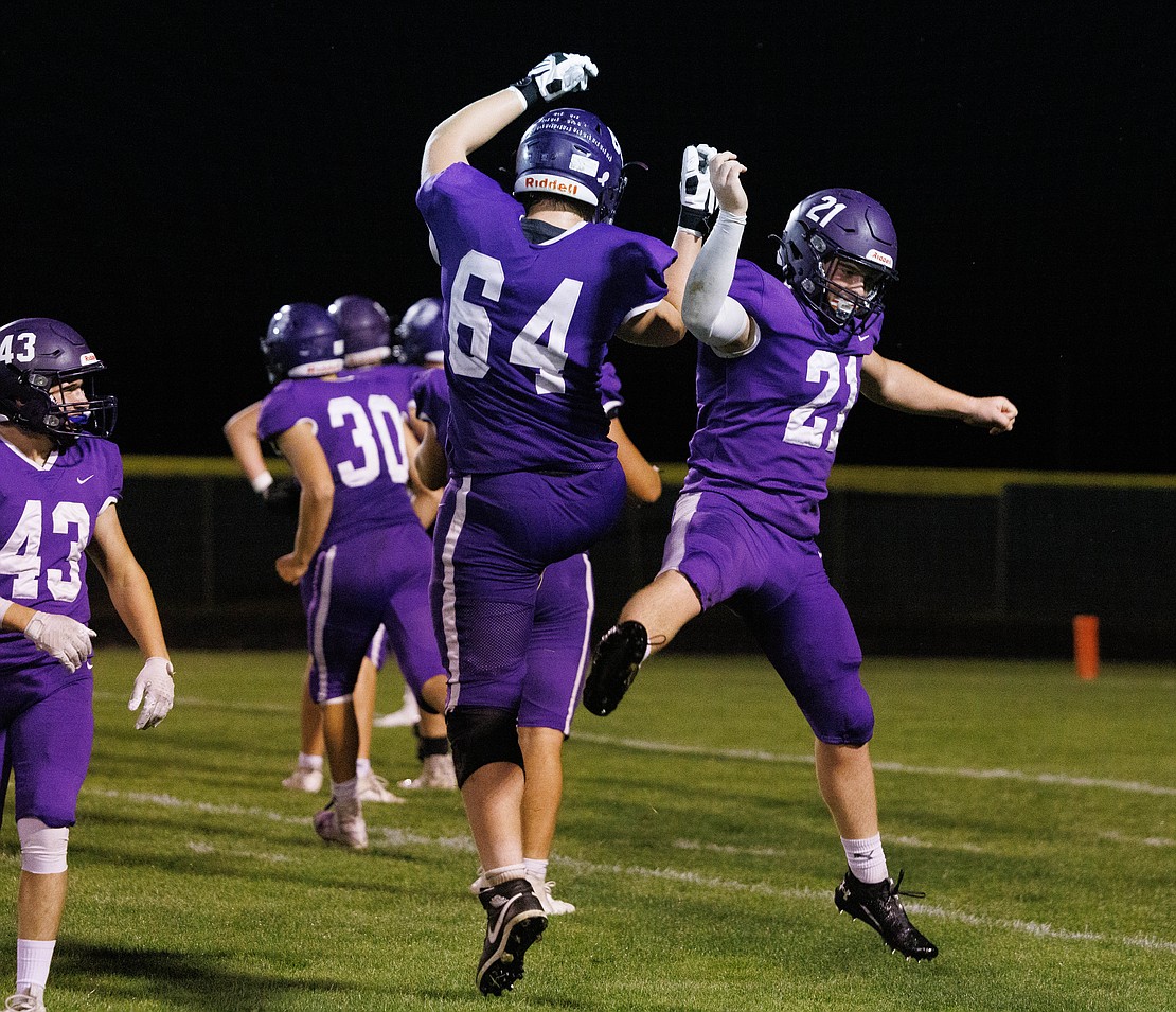 Nooksack Valley’s Brady Ackerman and Colby Martin (21) celebrate Martin’s interception for a touchdown in the third quarter.