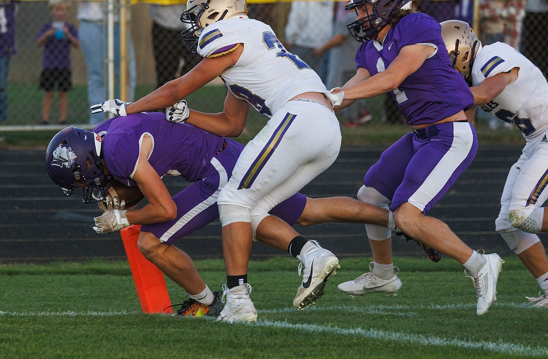 Nooksack Valley's Corey Olney tucks down to fight his way into the end zone for a touchdown in the first quarter.