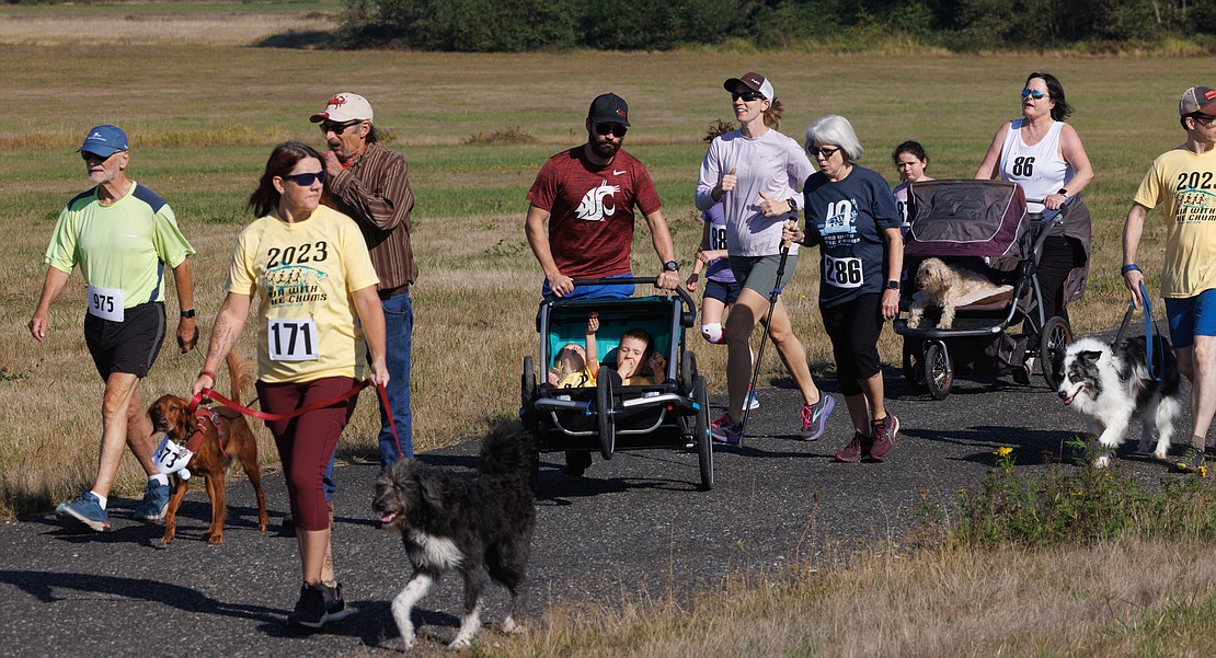 With two kids in a stroller, Tim Davis weaves his way through the crowd of runners, walkers and dogs.