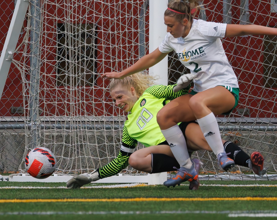 Bellingham goalie Opal Barker and Sehome’s Evelyn Sherwood battle for the ball, unaware a goal had been called after it bounced back into play.