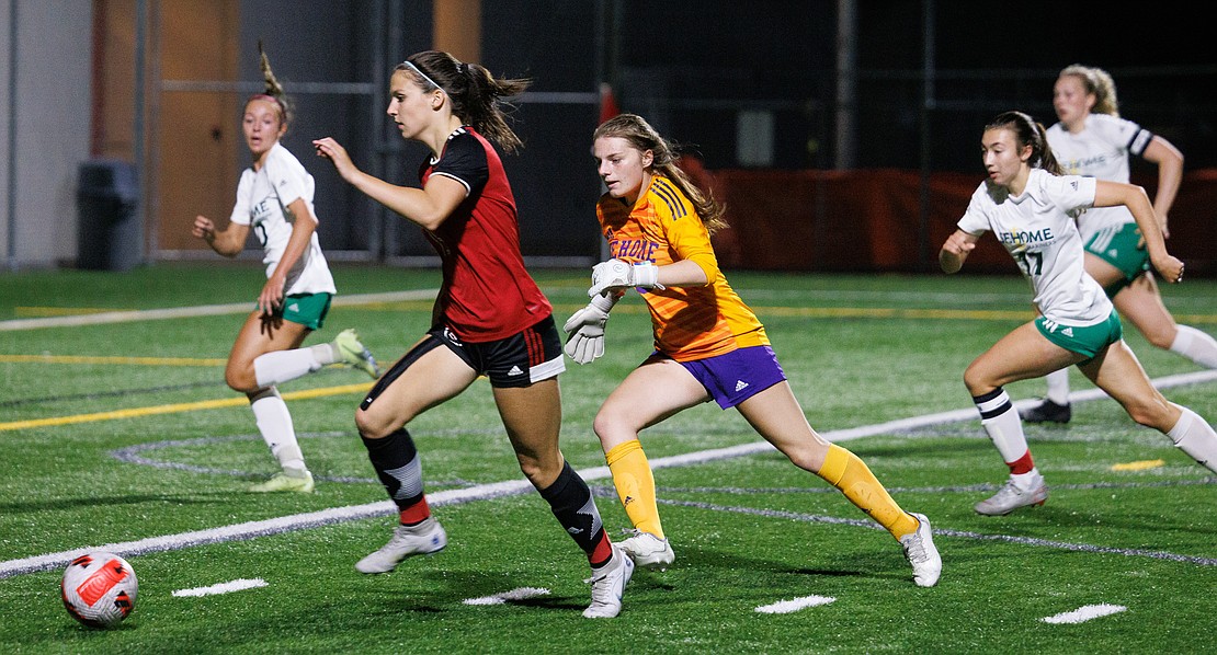 Bellingham’s Beckett Ferry gets past Sehome goalie Clarice Hickey but misses the shot on goal.