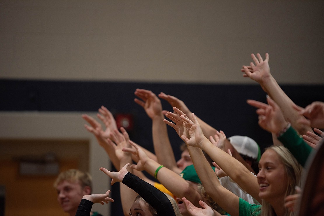 Lynden's student section wiggles their fingers during a serve.