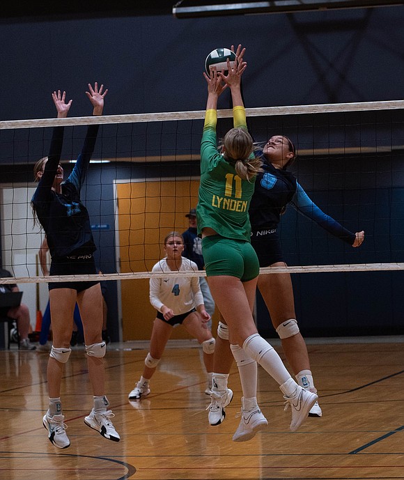 Lynden pin hitter Rian Stephan (11) and LC outside hitter Malia Johnson battle for a ball at the net.