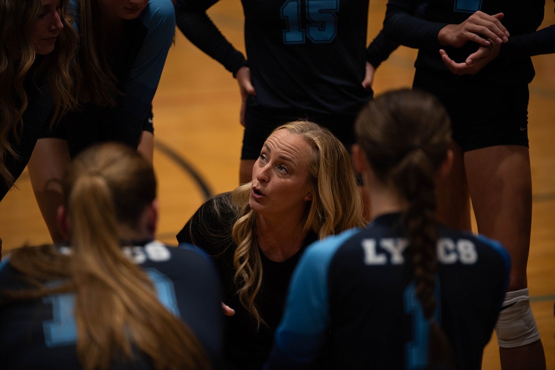 LC head coach Kristy VanEgdom talks to the team after the first set.
