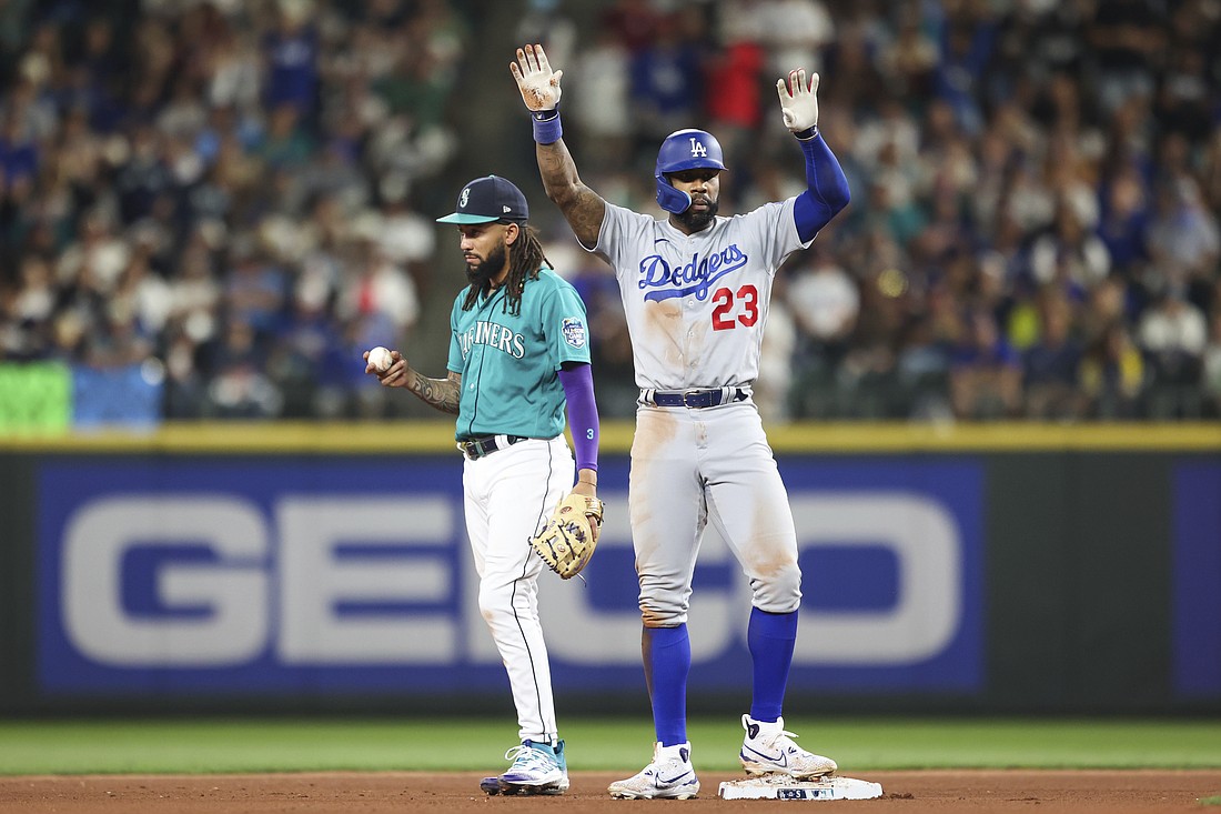 Los Angeles Dodgers' Jason Heyward celebrates after hitting a double as Seattle Mariners shortstop J.P. Crawford reacts during the seventh inning of a baseball game Saturday, Sept. 16, 2023, in Seattle.