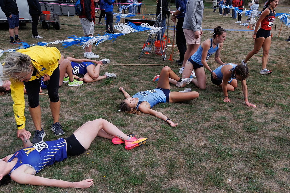 Western Washington University's Ashley Reeck helps up teammate Ila Davis as Mia Crocker lays out at the finish line.