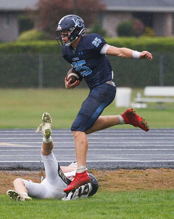 Lynden Christian’s Kayden Stuit leaps over a player to set up a touchdown.