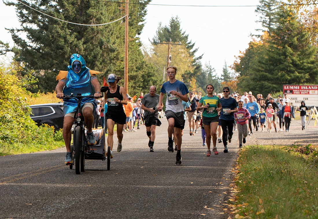 All business in his fish suit, Jesse Powell leads the 5K division Sunday, Oct. 8 along the route of the Lummi Island Loop race. More than 100 racers took part in the first-ever race.