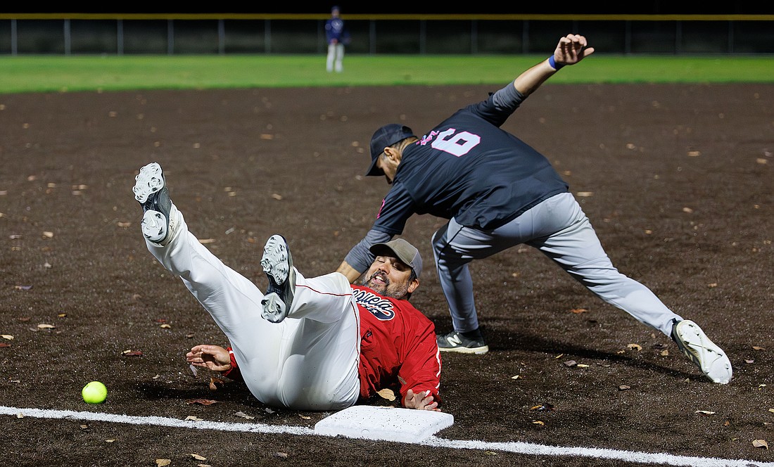 With the turf wet from rain, Romer Vivas nearly slides past third base on Tuesday, Oct. 10 as Jake Ruiz misses the ball, and the tag, during a softball game at the Lummi Nation Community Park and Ball Fields. “It’s beautiful to slide in,” Romer said of the wet conditions.