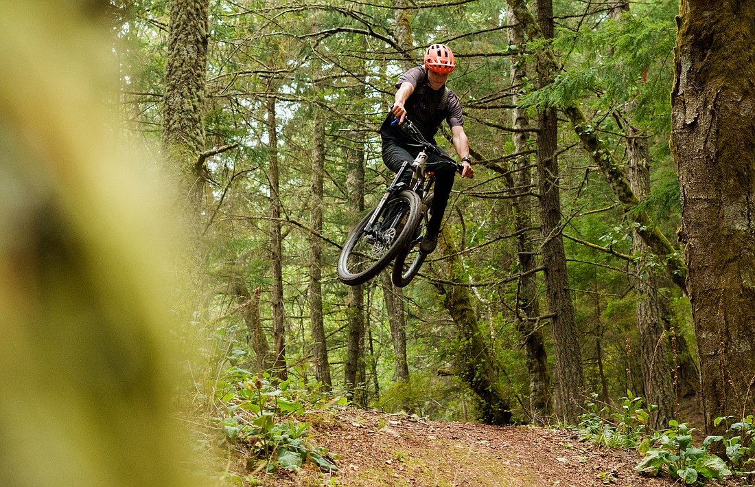 Talus Lantz tweaks his bike over a jump on Powerline trail on Orcas Island Oct. 9. The older, second-growth forests on Orcas make for undergrowth — a major appeal of the trails on the island. When given decades of time to recover from logging, a forest will absorb dead and fallen trees, and fungus breaks down old logs churning them into a layer of plush, red and brown dirt.