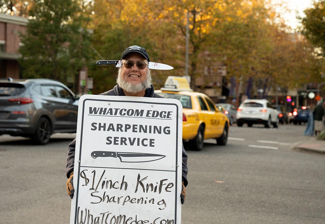 Truk Tolstad of Whatcom Edge holds his sign on the corner of State and Holly streets in downtown Bellingham on Tuesday, Oct. 31.