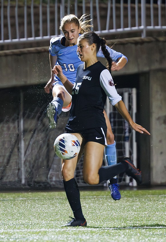 Western Washington University's Claire Potter takes a shot at the goal past a Seattle Pacific University defender.