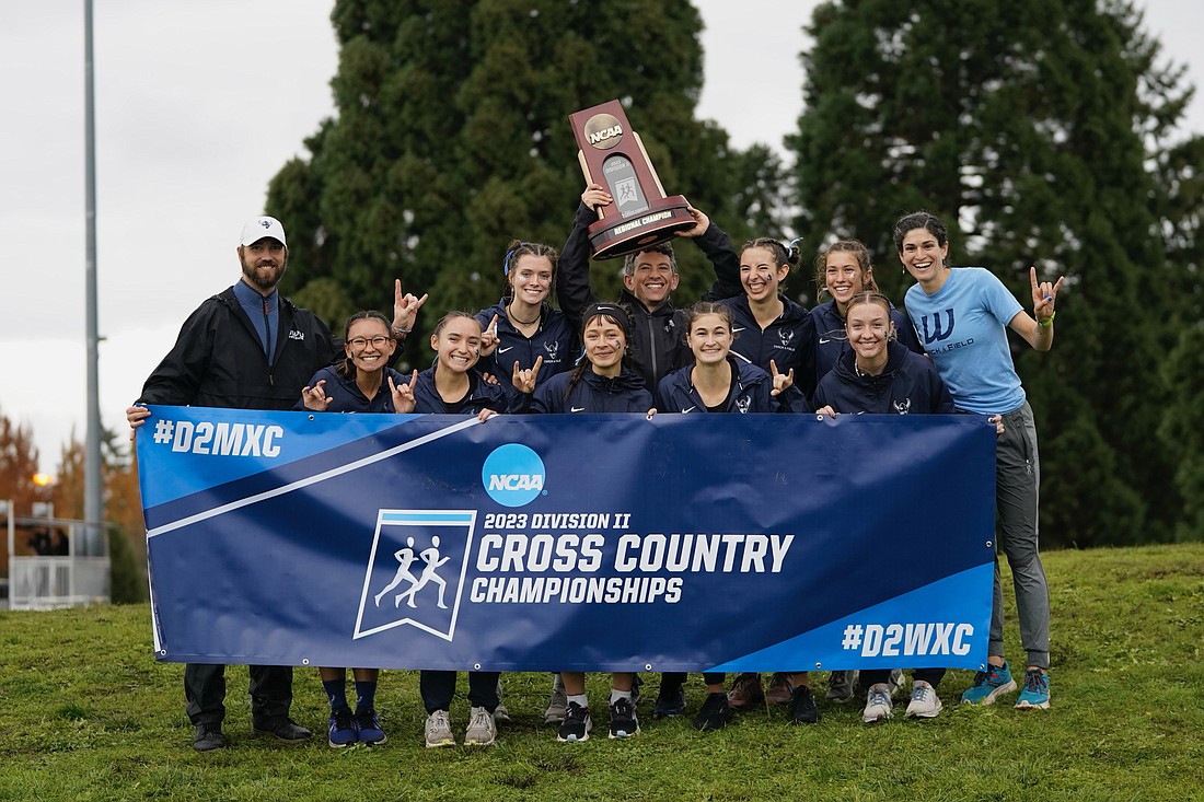 Western Washington University assistant coach and cross country lead T.J. Garlatz hoists the women's NCAA Division II West Regional championship trophy Saturday, Nov. 4 at the Ash Creek Preserve in Monmouth, Oregon. The Vikings' women team captured the first-ever regional title across both Western cross country programs since the school joined the NCAA in 1998.