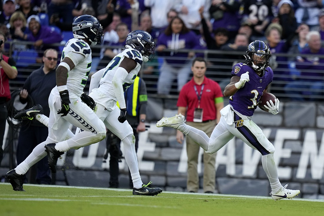 Baltimore Ravens running back Keaton Mitchell runs from Seattle Seahawks defenders during a 40-yard touchdown run in the second half Sunday, Nov. 5 in Baltimore.