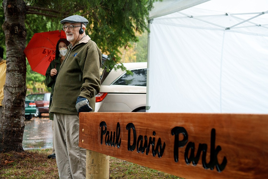 Paul Davis, 97, stands next to the sign for the newly named Paul Davis Park, formerly referred to as "ferry orchard park" by the locals and "ferry parking lot" by visitors, Saturday, Nov. 4.