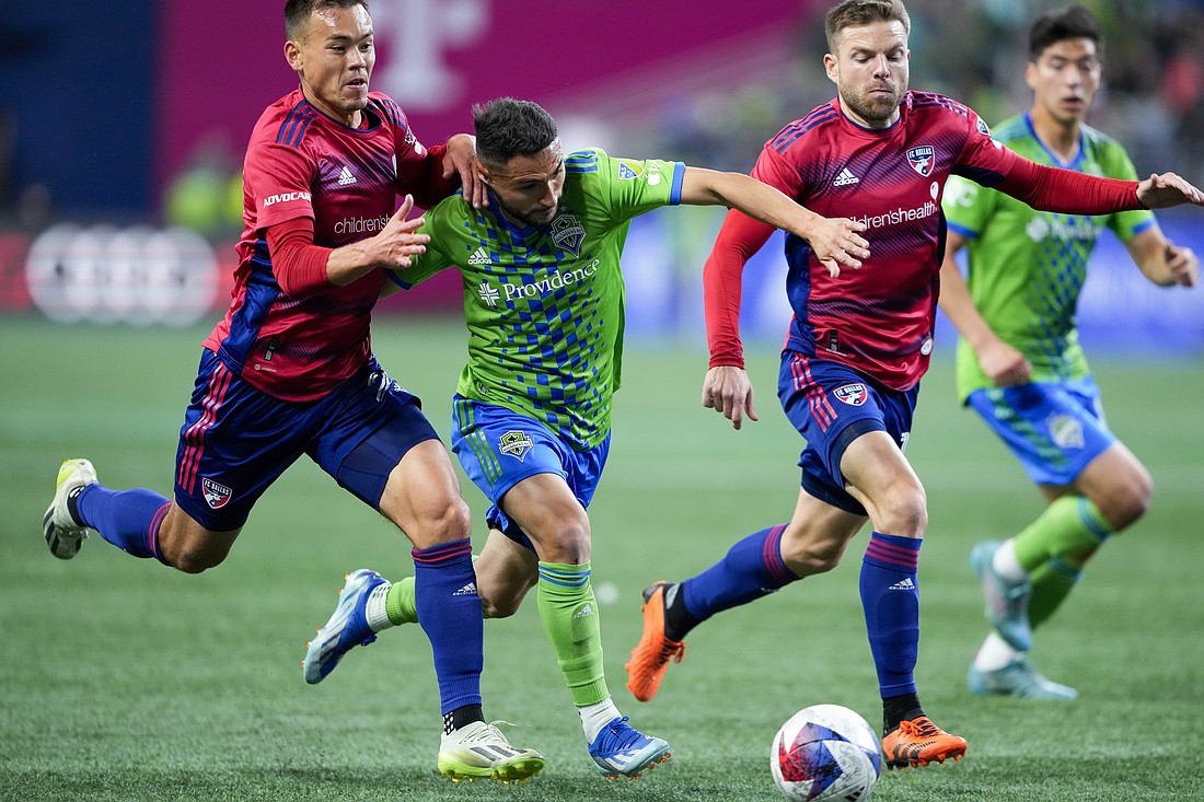 Seattle Sounders midfielder Cristian Roldan, second from left, drives the ball while pursued by FC Dallas defender Sam Junqua, left, and midfielder Asier Illarramendi, right, during the first half of Game 3 of a first-round playoff MLS soccer match Friday, Nov. 10, in Seattle.