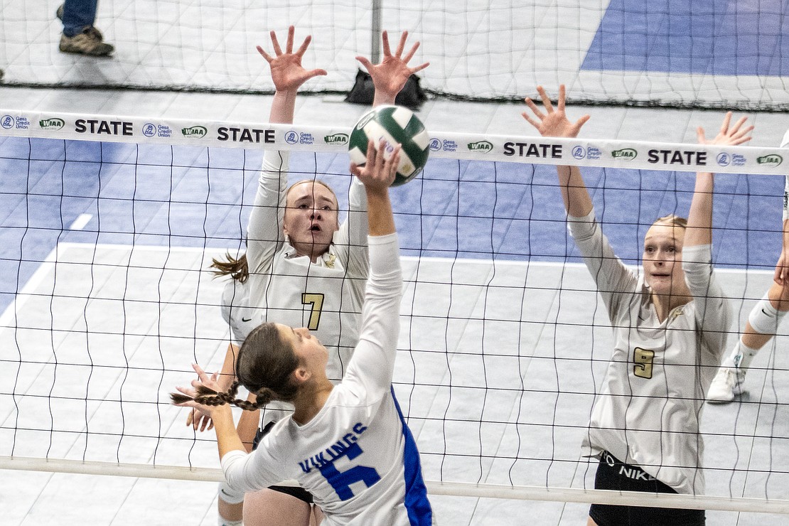 Meridian's Maren Wefer (7) and Gracie Pap (9) go for a block on a Bellevue Christian spike.