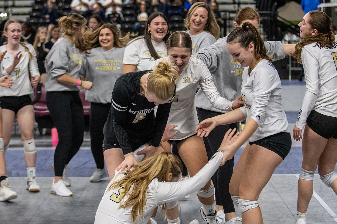 Meridian players help Emry Claeys off the floor Friday, Nov. 10, after the Trojans defeated Nooksack Valley in five sets to advance to the 1A state semifinals.