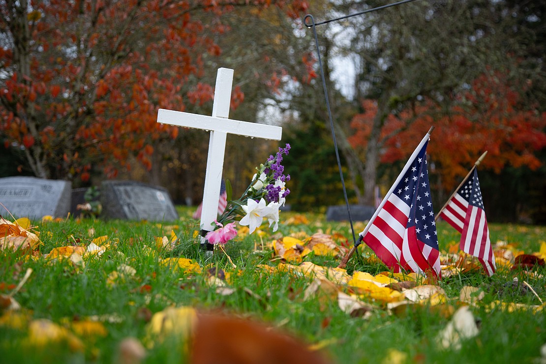 American flags decorate gravesites of veterans who've passed. The scouts spent the rainy morning cleaning headstones.