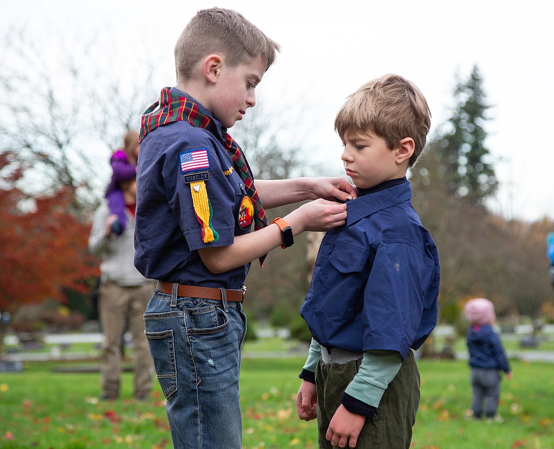 Cub scout Tanner Nelson, 10, left, helps Allen Bertagnolli, 6, button his collar before the ceremony.
