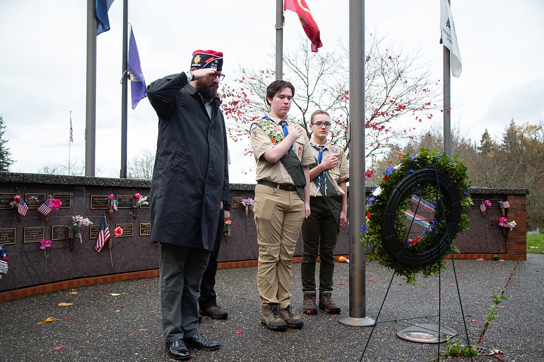 Veteran Jesse Atkins salutes a wreath honoring veterans with a group of boys scouts. Atkins is a Navy veteran who spent three years on submarines and is a current member of VFW 1858 in Bellingham.