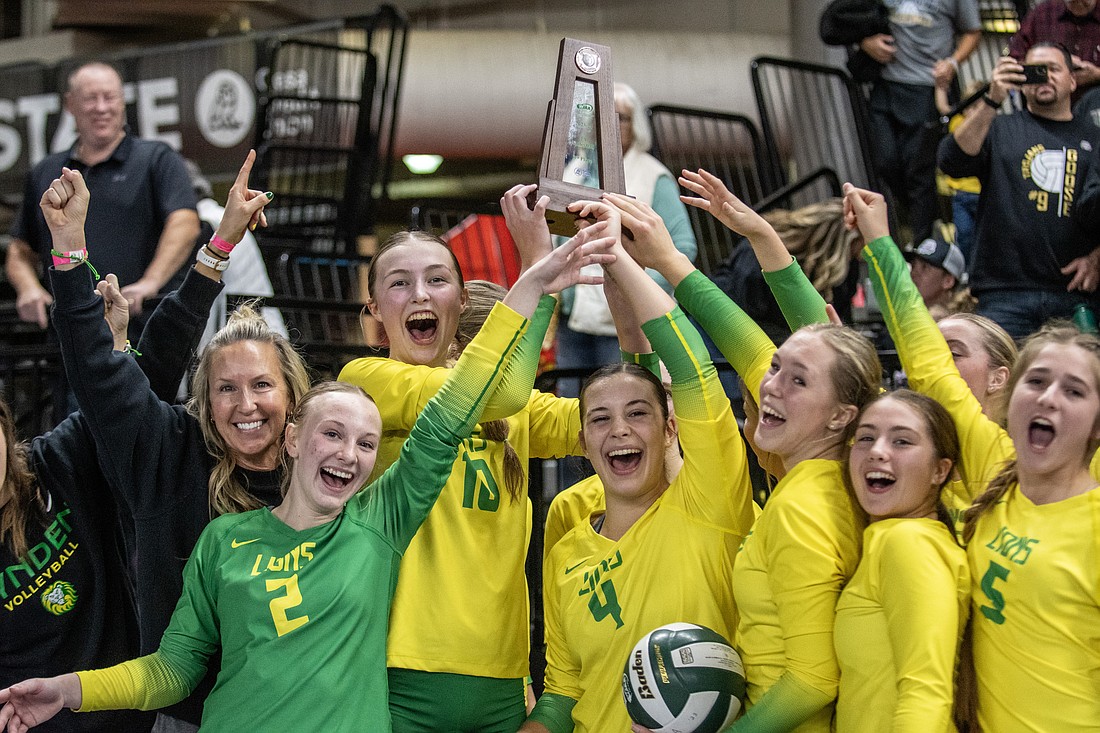 Lynden celebrates with its third-place trophy at the 2A state tournament Saturday, Nov. 11, after sweeping Burlington-Edison in the third/fourth-place match at the Yakima Valley SunDome.