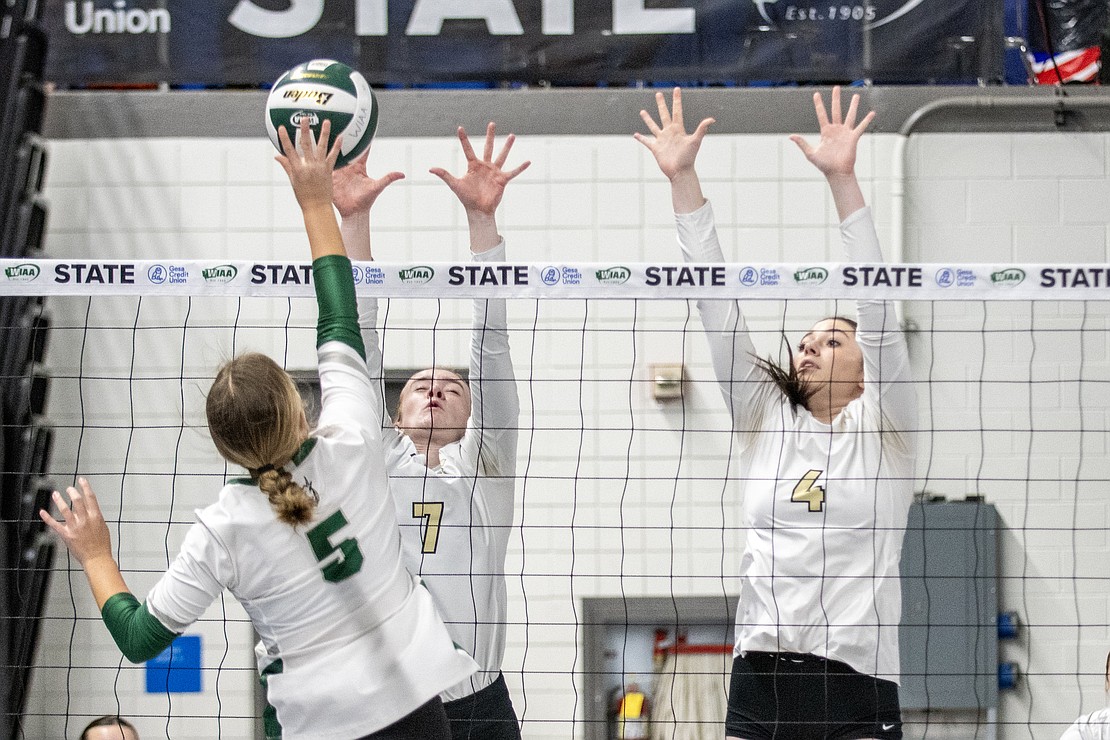 Meridian's Maren Wefer (7) and Taya Benson (4) go up for a shot-block attempt on Chelan.