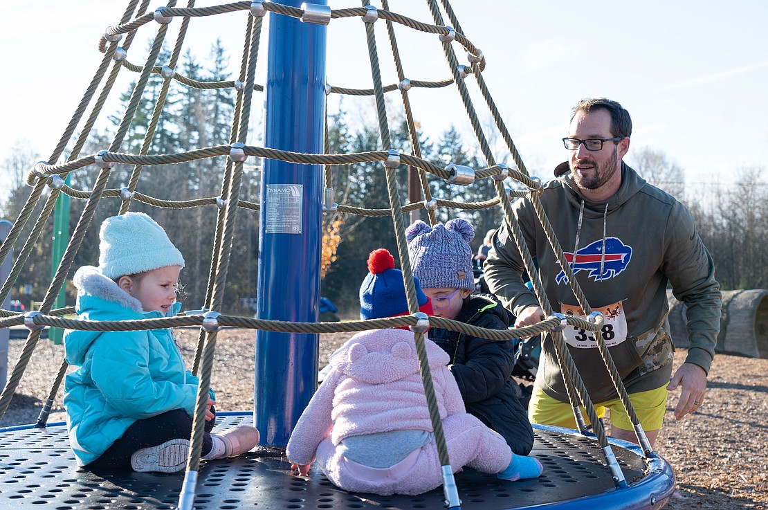 Nick Washburn pushes the rotating playground feature for his daughter and his friend's kids. He and his daughter attempted the 5K with him pushing her in a stroller, but she wasn't having it, he said. "I think we're playground-bound," he said.