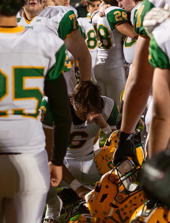 Lynden junior quarterback Brant Heppner wipes a tear as his teammates console each other around him.
