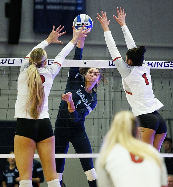 Western's Delaney Speer puts a spike between two Central Washington blockers.