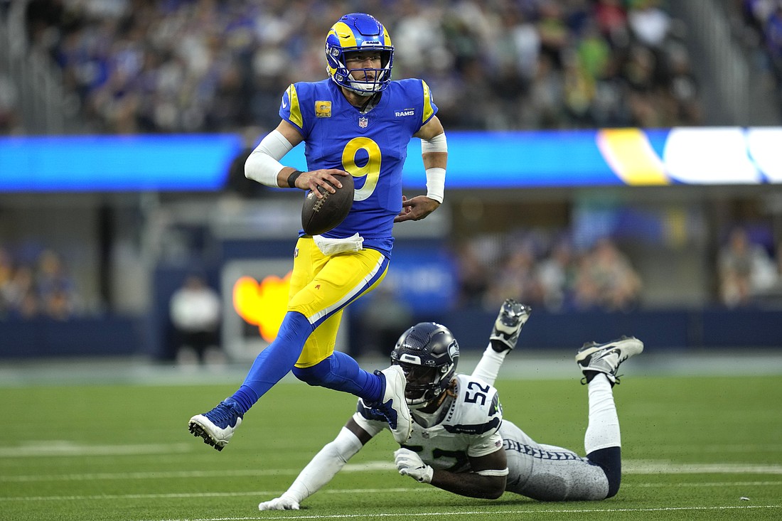 Los Angeles Rams quarterback Matthew Stafford (9) runs the ball after evading a tackle from Seattle Seahawks linebacker Darrell Taylor (52) Sunday, Nov. 19 in Inglewood, Calif.